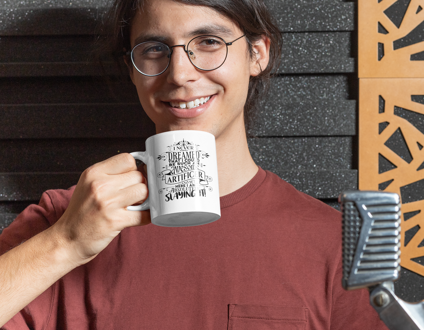 a man holding a coffee mug in front of a wall